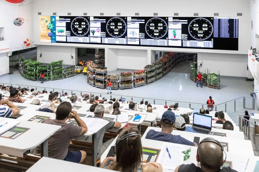 Pessoas em leilão de flores sentadas em um auditório